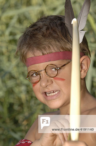 Junge beim Indianerspielen mit Pfeil und Bogen