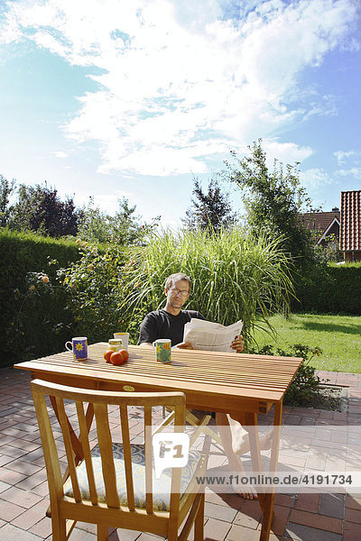 Lesender Mann im Garten