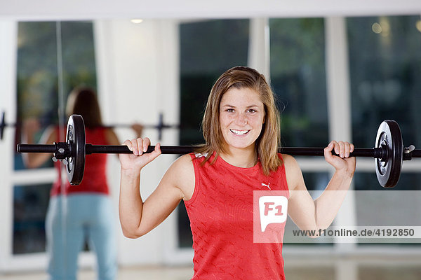 Eine junge Frau trainiert mit Gewichten