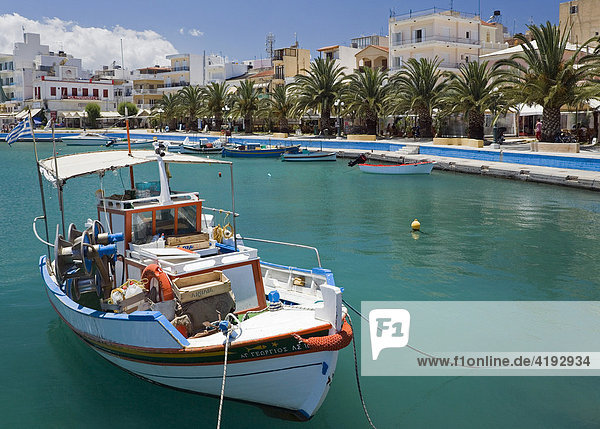 Hafenpromenade von Sitia mit ihren Palmen  im Vordergrund ein Fischerboot  Sitia  Ostkreta  Kreta  Griechenland