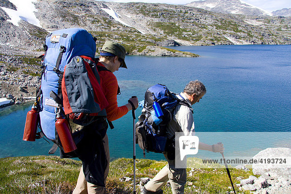 Hikers carrying backpacks at Crater Lake  mountain landscape  Chilkoot Trail  British Columbia  Canada