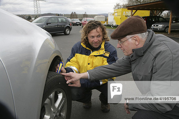 Dirk Mueller  ADAC (German automobile club) instructor explaining the importance of the correct tire tread depth and air pressure to a participant in the senior’s safety training at the practice area in Koblenz  Germany  25.03.2008