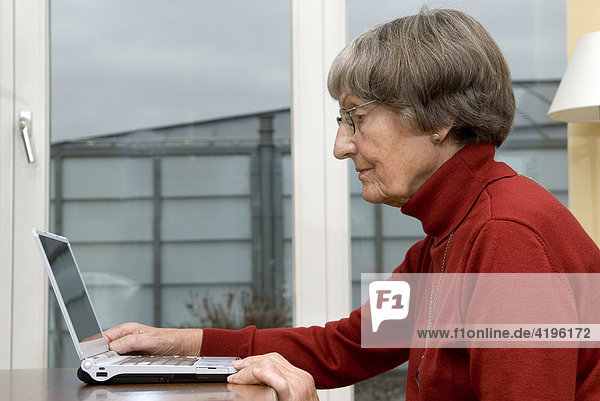 Aktive Rentnerin arbeitet an einem Notebook