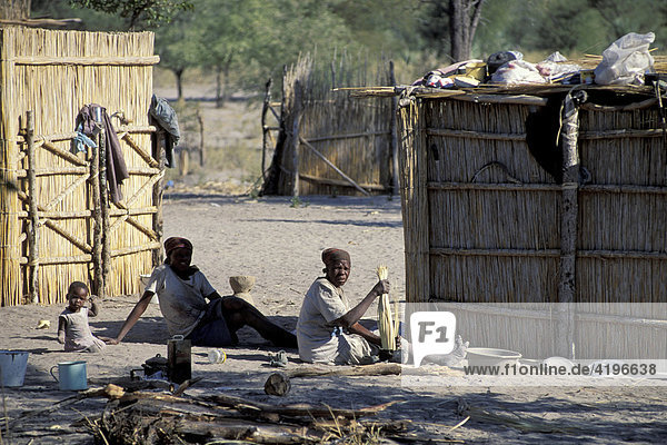 Familie sitzt vor Huette Botswana