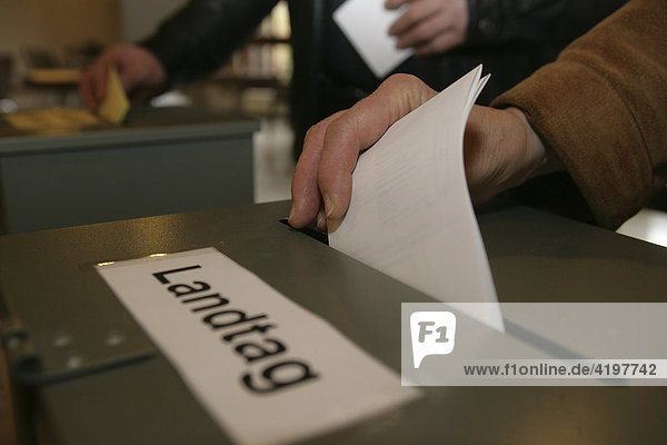 Ein Bürger wirft seine Stimme bei der Landtagswahl in die Wahlurne.