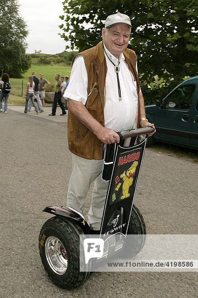 Hans Riegel  Factory owner of the gummi bear producer Haribo  on a electrician scooter from Segway