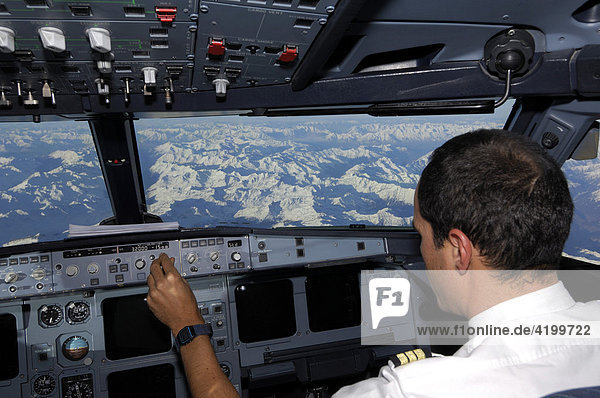 Pilot im Cockpit eines Airbus 321 beim Flug über die Alpen