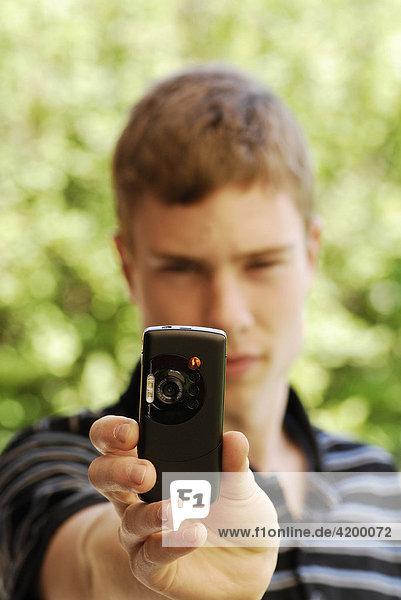 Jugendlicher fotografiert mit Handy