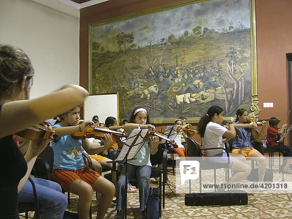 Paraguayan Children playing violins in front of a huge painting  Concepcion  Paraguay