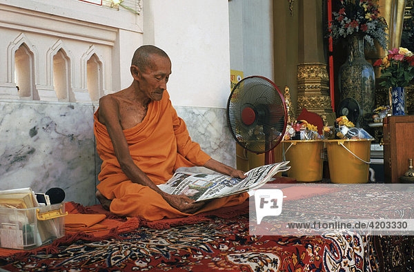 Elderly monk reading newspaper  Nakhon Pathom  Thailand  Asien