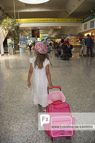 Mädchen mit Trolley am Flughafen Sardinien Olbia