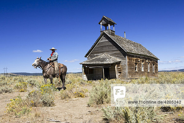 Cowboy auf Pferd vor altem Schulhaus  Wilder Westen  Oregon  USA