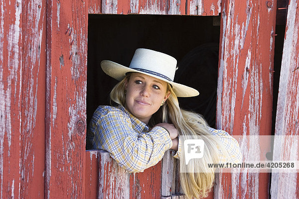 Cowgirl schaut aus Scheunenfenster  Wilder Westen  Oregon  USA