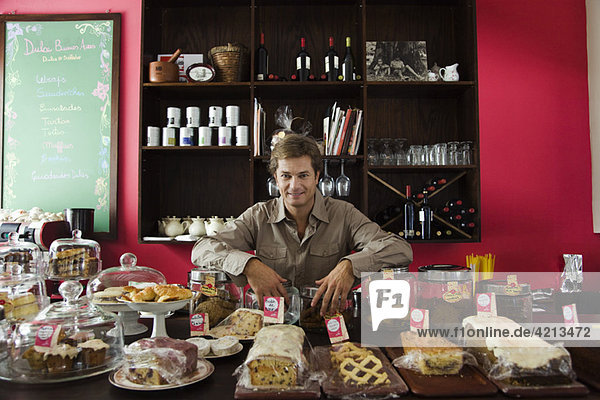Cafe owner  assorted pastries and baked goods on counter