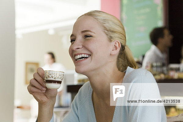 Junge Frau trinkt Kaffee im Café
