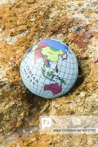 Globe nestled in rock