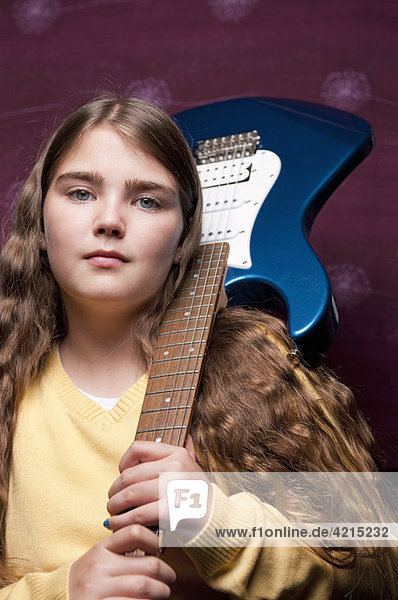 Junges Mädchen mit Gitarre auf der Schulter