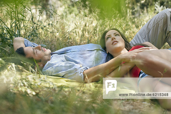 Couple lying on blanket in long grass