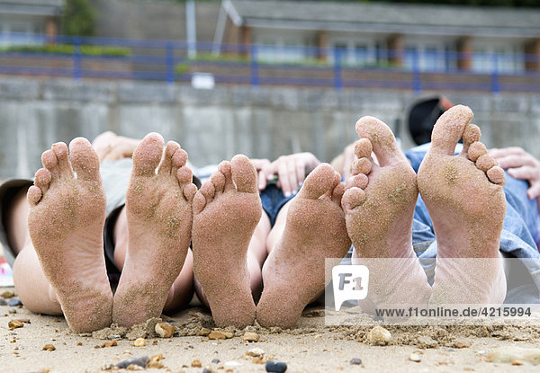 Familien mit sandigen Füßen am Strand