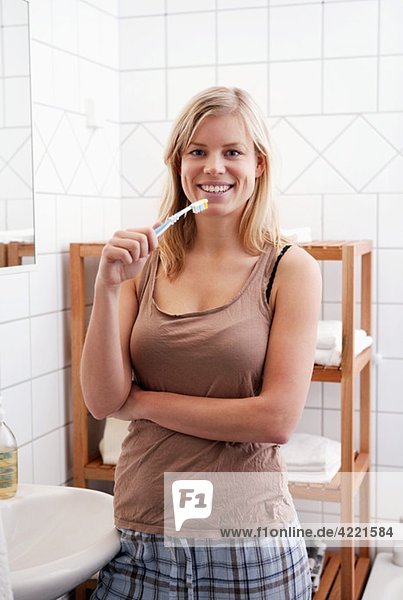 woman standing in the bathroom with her toothbrush
