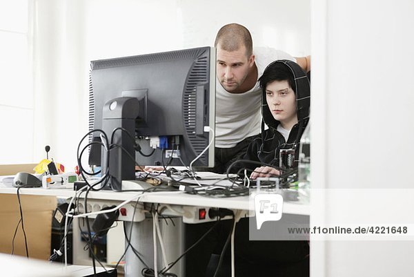Zwei Menschen helfen sich gegenseitig am Computer.