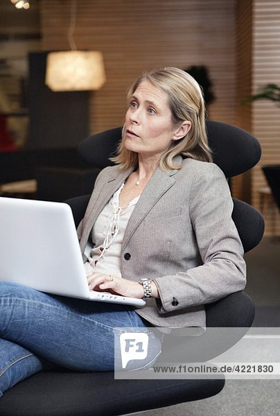Frau auf Stuhl mit Laptop