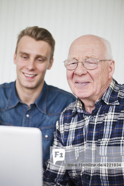 Elderly man and guy with laptop