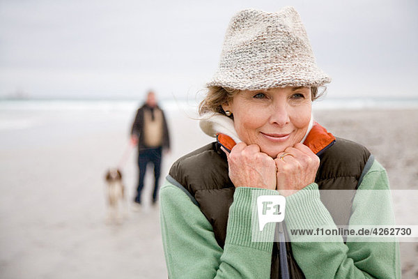 Frau am Strand  Mann und Hund im Hintergrund