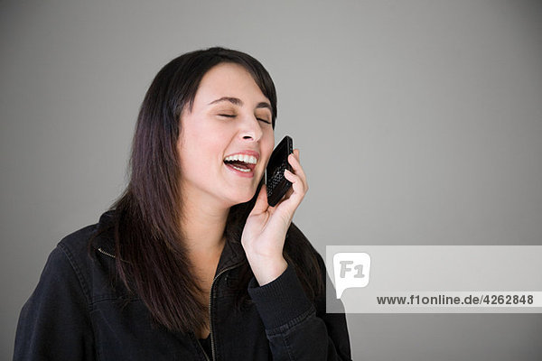 Teenage girl laughing on smartphone