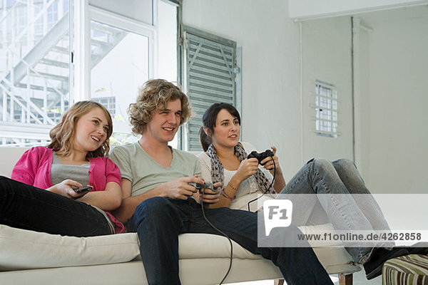 Teenagers playing on games console
