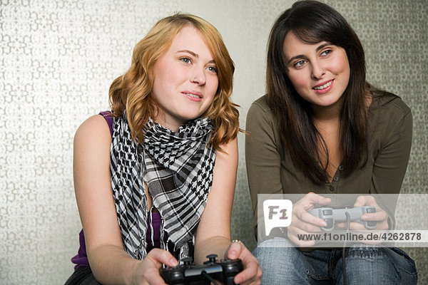 Teenage girls playing on games console