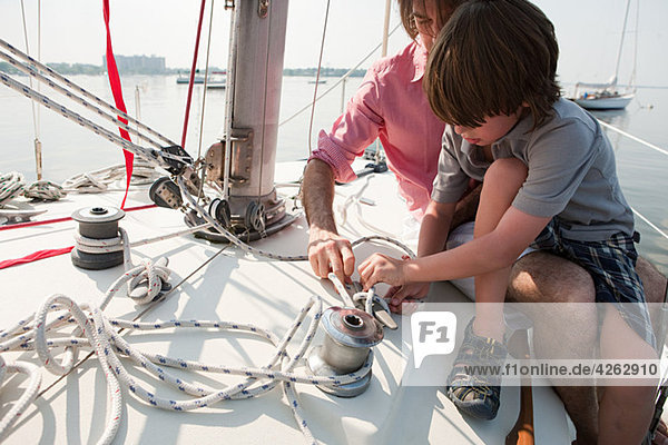 Vater und Sohn an Bord der Yacht mit Seil
