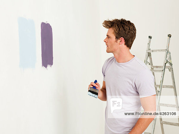 Junger Mann mit Farbe an der Wand
