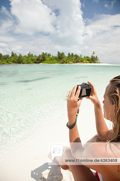Woman taking picture  Medahutthaa Island  North Huvadhu Atoll  Maldives
