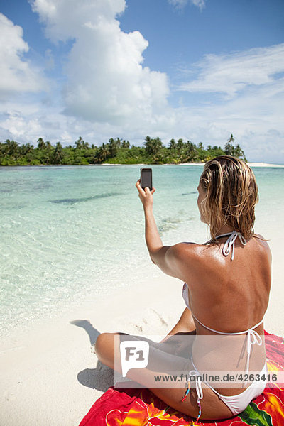 Woman taking picture  Medahutthaa Island  North Huvadhu Atoll  Maldives