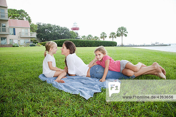Happy Mother und Töchter auf Gras liegend