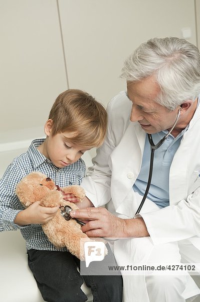 Junge mit Teddybär beim Arzt
