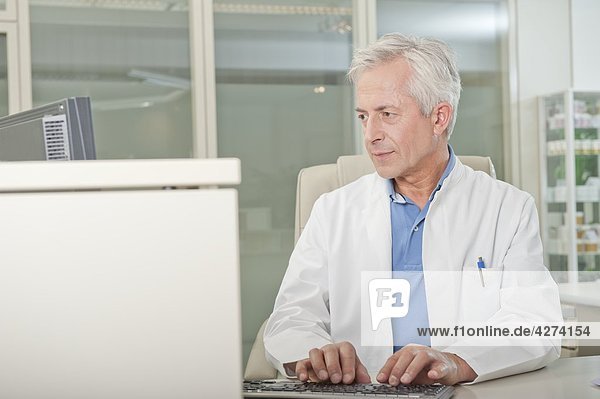 Arzt benutzt Computer am Schreibtisch