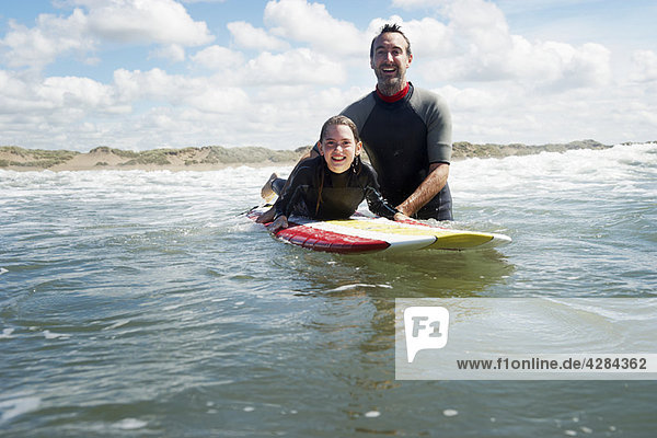 Vater und Tochter surfen im Meer