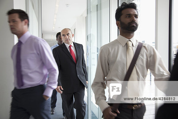 Business people walking fast past camera