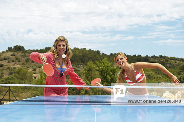 Zwei Frauen spielen Tischtennis im Freien