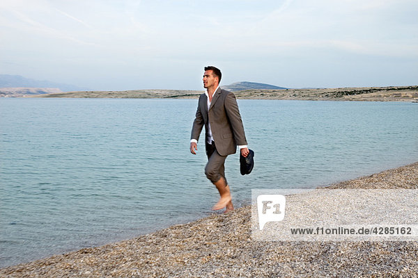 Businessman walking on the beach