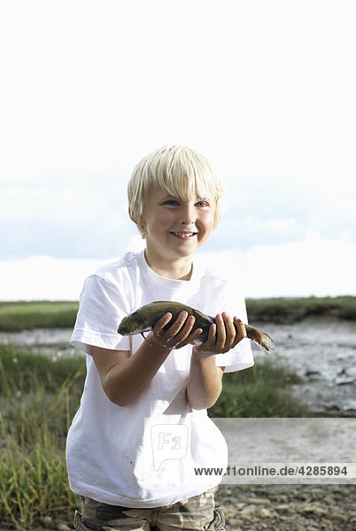 Boy holding fish up