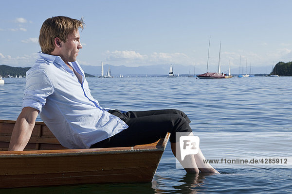 Geschäftsmann entspannt auf einem Ruderboot