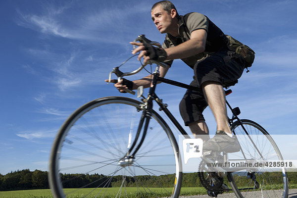 Mann fährt schnell mit dem Rennrad