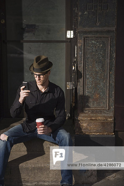 Man with coffee and a cell phone