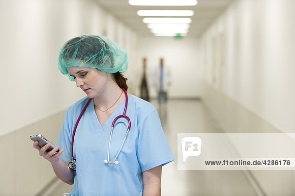 Krankenschwester im Krankenhausflur mit Handy