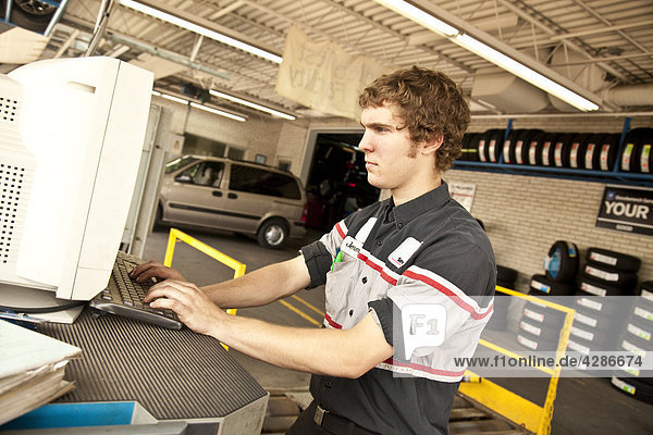 Young mechanic working on a computer