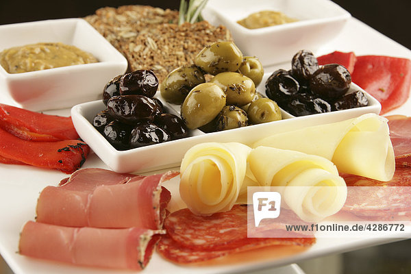 Platter in Scheiben geschnitten  Fleisch  Käse  Dip und Oliven