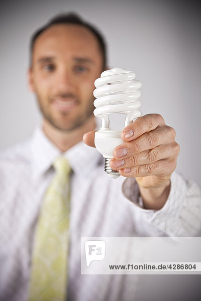 Unternehmer hält einer effizienten Energie-Glühlampe